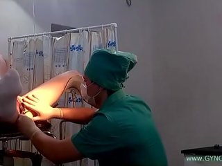 एक युवा युवा महिला में वाइट सॉक्स पर एक जिनेकोलॉजिकल कुरसी